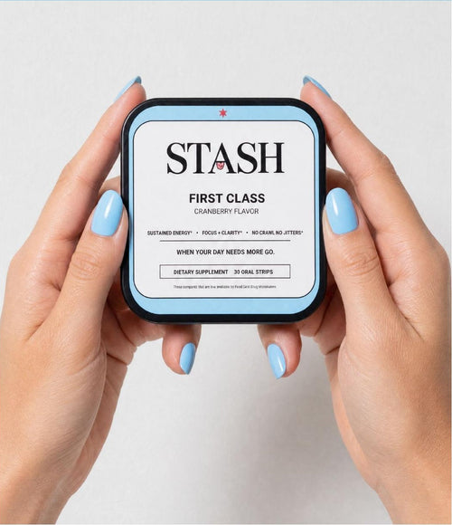 Two hands holding the STASH FIRST CLASS cranberry energy strips tin